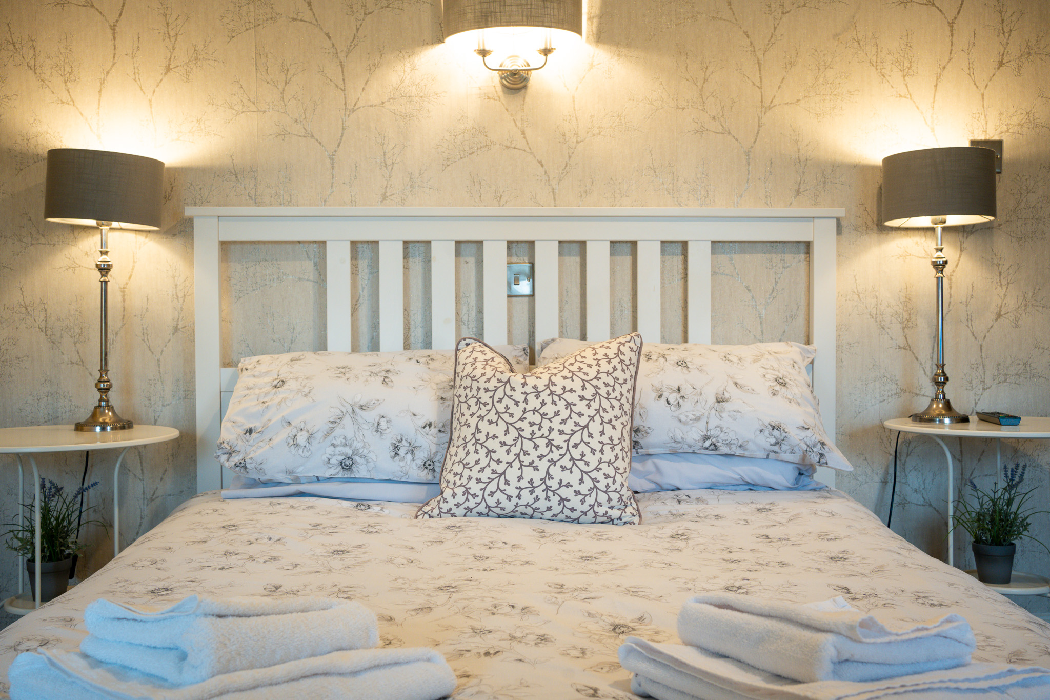 wensleydale-king-bed a bed illuminated by wall lights